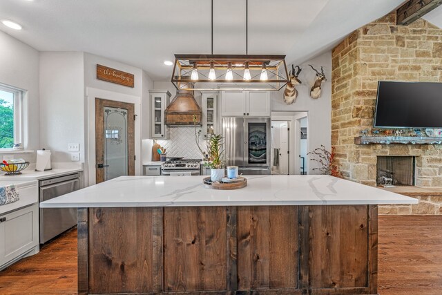 kitchen with stainless steel appliances, dark wood-style flooring, decorative backsplash, glass insert cabinets, and custom range hood