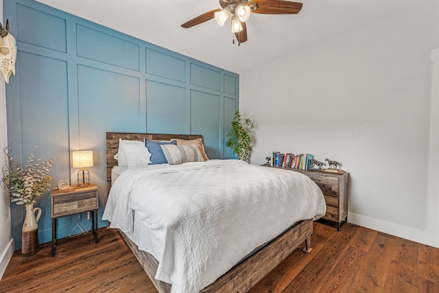 bedroom with baseboards, a ceiling fan, and dark wood-type flooring