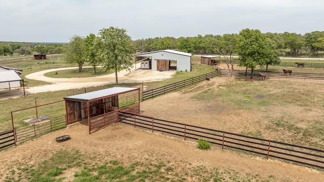 view of yard featuring a rural view, an outdoor structure, an outbuilding, and an exterior structure