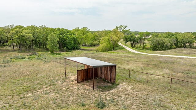 view of yard featuring fence, an outbuilding, a rural view, and a pole building