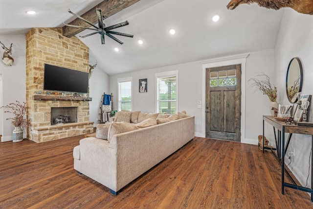 living area featuring vaulted ceiling with beams, baseboards, wood finished floors, ceiling fan, and a stone fireplace
