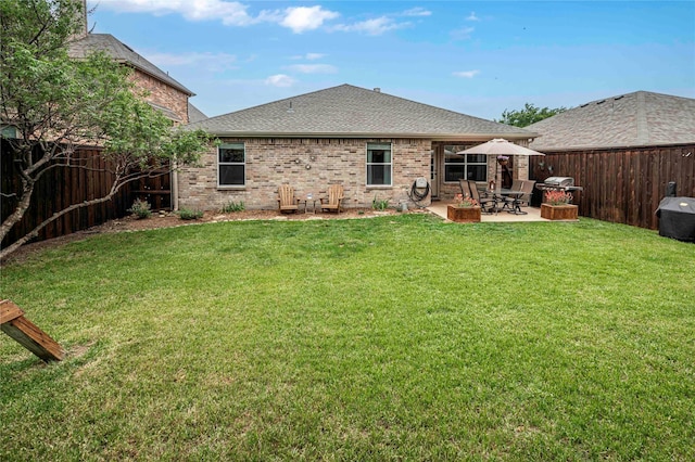 back of property featuring a lawn, a shingled roof, and a fenced backyard