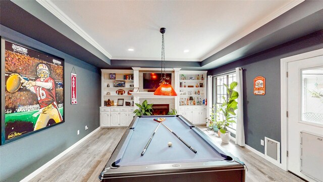 game room featuring light wood-type flooring, ornamental molding, billiards, and a fireplace