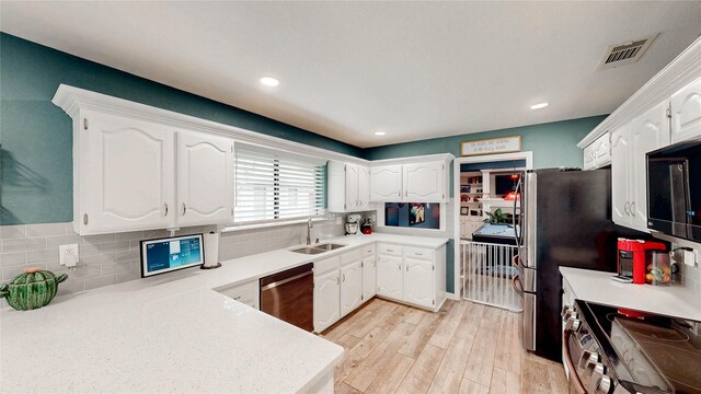 kitchen featuring a sink, light countertops, stainless steel appliances, and white cabinetry