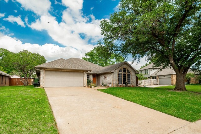 ranch-style house featuring concrete driveway, brick siding, and a front lawn