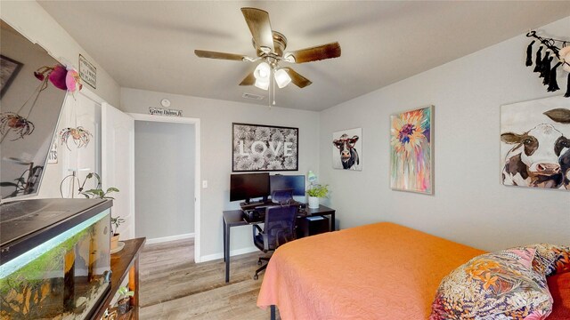 bedroom featuring light wood-style floors, baseboards, ceiling fan, and visible vents