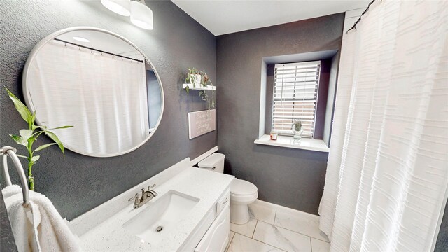 bathroom featuring vanity, toilet, a shower with shower curtain, marble finish floor, and baseboards