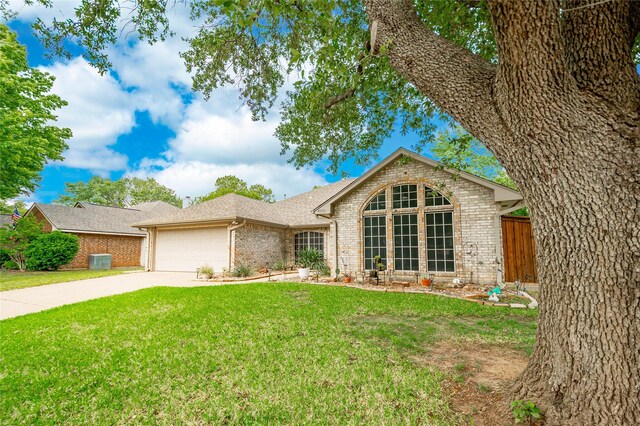 ranch-style home with fence, a front yard, brick siding, concrete driveway, and an attached garage