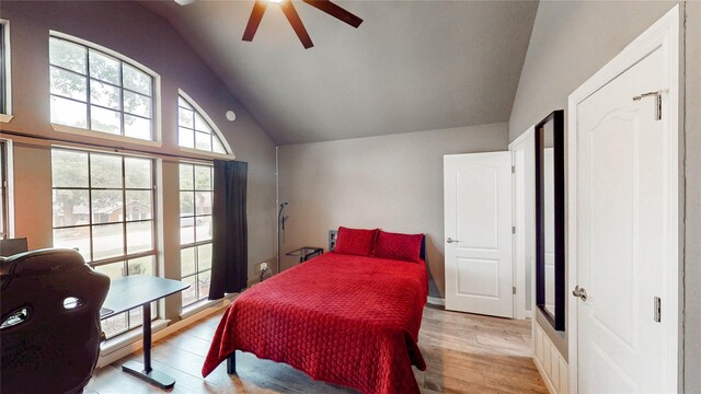 bedroom featuring a ceiling fan, light wood-style flooring, and lofted ceiling