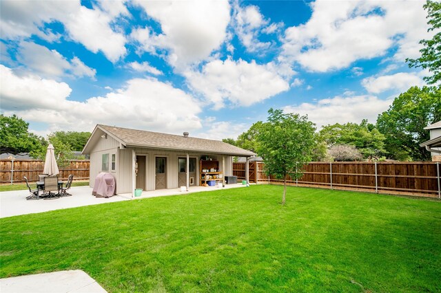 rear view of property with a fenced backyard, a yard, and a patio area