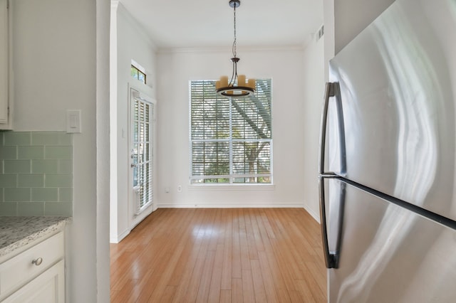3311 Blackburn St Unit 104, Dallas, TX 75204 - unfurnished dining area with baseboards, ornamental molding, visible vents, and light wood finished floors