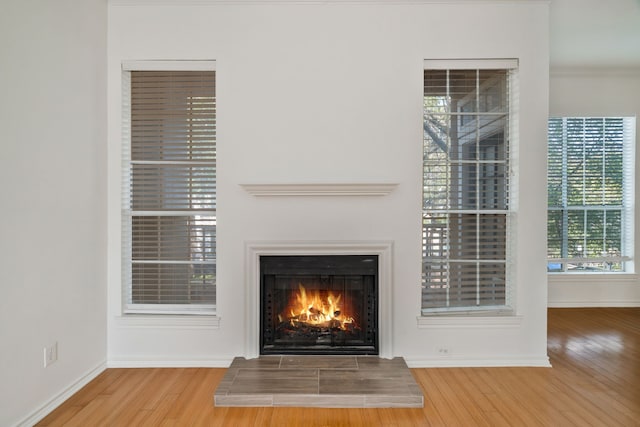 3311 Blackburn St Unit 104, Dallas, TX 75204 - room details featuring baseboards, wood finished floors, and a warm lit fireplace