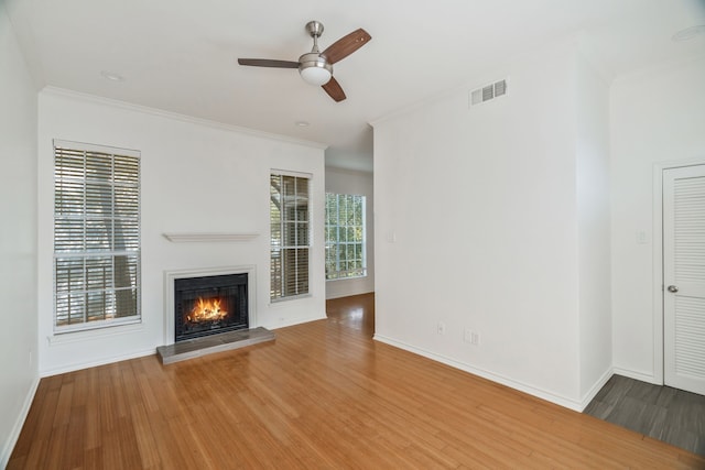 3311 Blackburn St Unit 104, Dallas, TX 75204 - unfurnished living room with a glass covered fireplace, visible vents, wood finished floors, ceiling fan, and crown molding