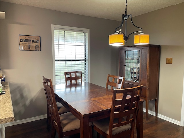 dining area with baseboards and dark wood-style floors