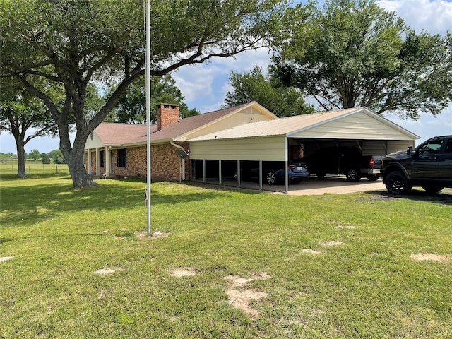 view of side of property featuring a detached carport, a lawn, a chimney, and brick siding