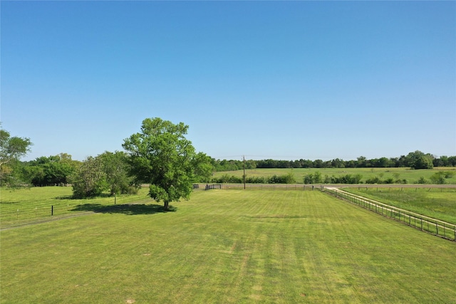 view of yard with fence and a rural view