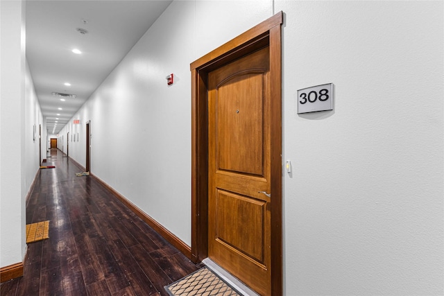 hall featuring baseboards, hardwood / wood-style floors, visible vents, and recessed lighting