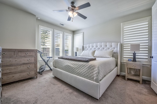 bedroom with a ceiling fan, baseboards, visible vents, and light carpet