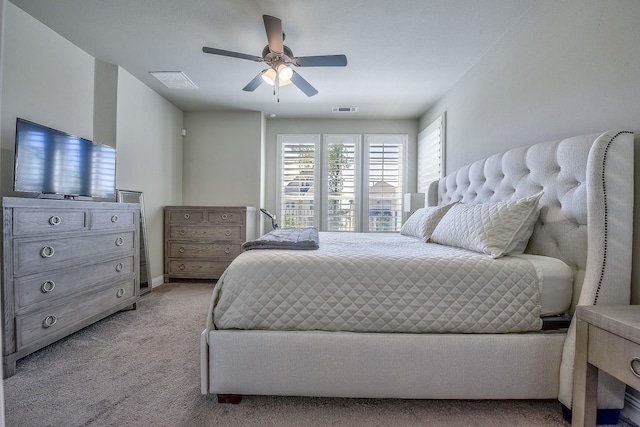 bedroom featuring visible vents, baseboards, ceiling fan, and light carpet
