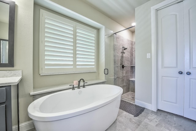 bathroom featuring vanity, marble finish floor, a freestanding tub, and a shower stall