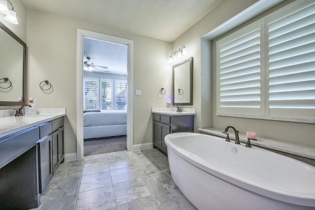 bathroom with a ceiling fan, a freestanding tub, two vanities, a sink, and marble finish floor