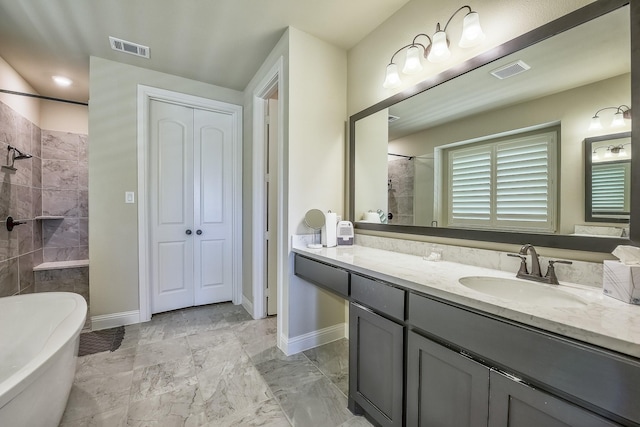 bathroom featuring a freestanding bath, vanity, a tile shower, and visible vents