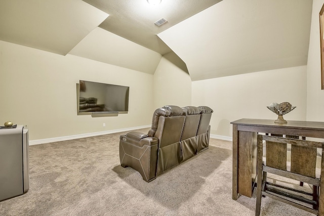 carpeted home theater room with baseboards, vaulted ceiling, and visible vents