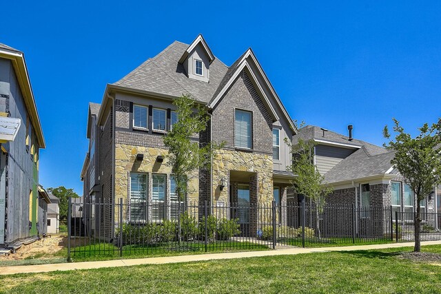 exterior space featuring brick siding, a front yard, fence, and stone siding