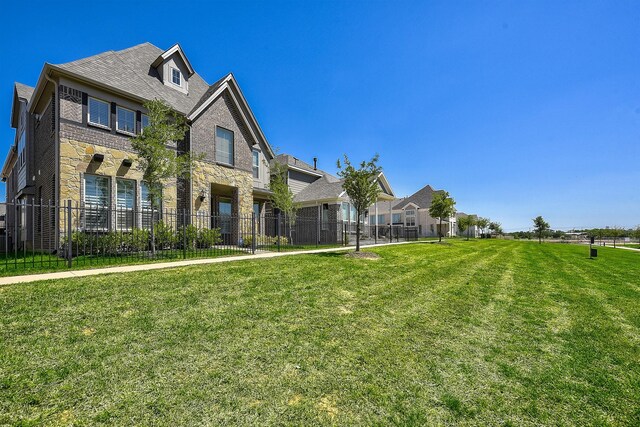 view of front of home featuring a garage, fence, a front lawn, concrete driveway, and stone siding
