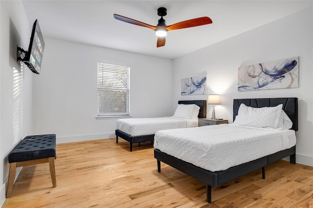 bedroom with baseboards, a ceiling fan, and light wood-type flooring