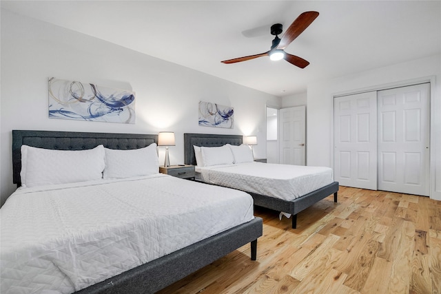 bedroom with ceiling fan, light wood-style floors, and a closet