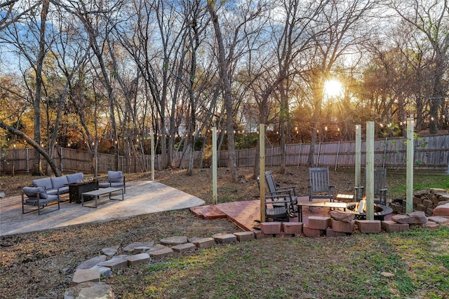 view of yard with a fenced backyard, an outdoor living space with a fire pit, and a patio