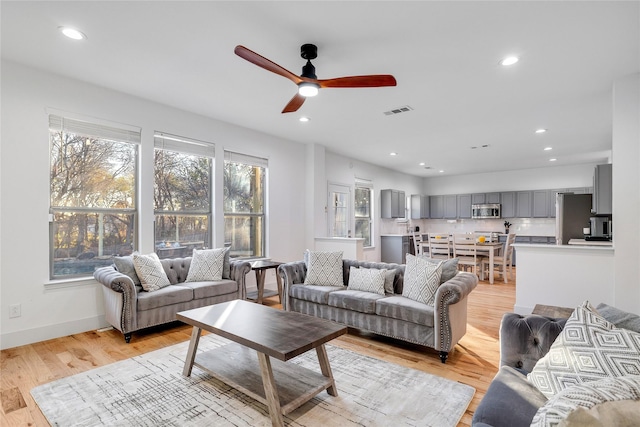 living room with ceiling fan, light wood-style flooring, visible vents, and recessed lighting