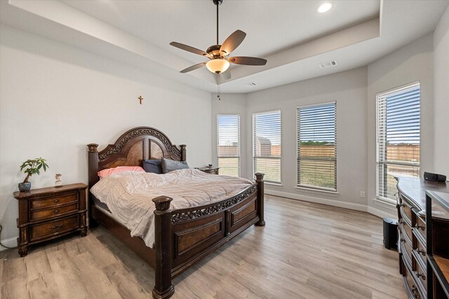 351 Evening Fire Dr, Waxahachie, TX 75167 - bedroom featuring visible vents, baseboards, light wood-style flooring, and a tray ceiling