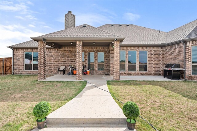 351 Evening Fire Dr, Waxahachie, TX 75167 - rear view of house featuring a chimney, brick siding, a shingled roof, a yard, and a patio