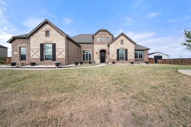 351 Evening Fire Dr, Waxahachie, TX 75167 - french country home with fence, a shingled roof, a front lawn, stone siding, and brick siding