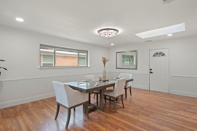 dining space featuring recessed lighting, wood finished floors, and a skylight