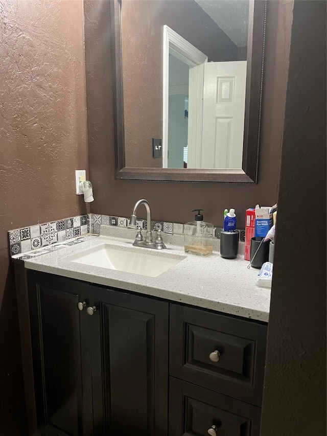 bathroom with vanity and a textured wall
