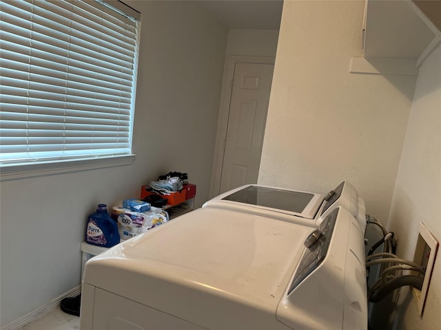 clothes washing area with baseboards, laundry area, and washing machine and clothes dryer