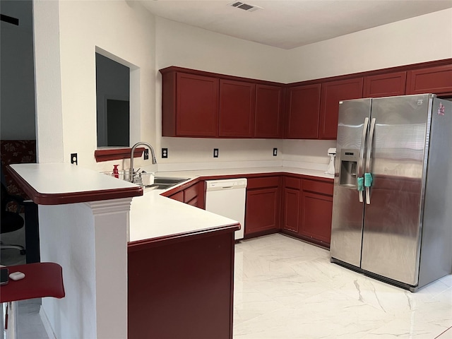 kitchen with white dishwasher, stainless steel fridge, a sink, marble finish floor, and a peninsula