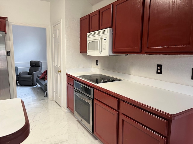 kitchen featuring light countertops, dark brown cabinets, appliances with stainless steel finishes, and marble finish floor