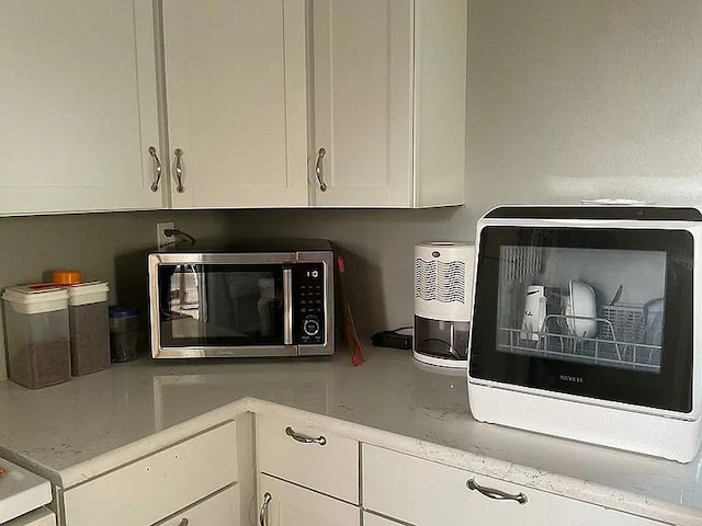 interior details featuring stainless steel microwave and white cabinetry