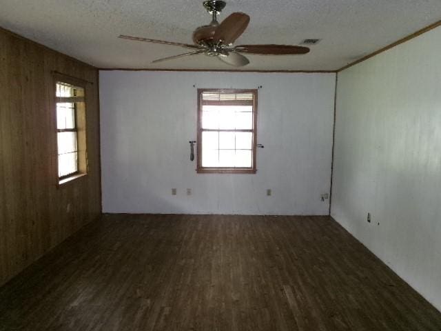 spare room with plenty of natural light, wood finished floors, and ceiling fan