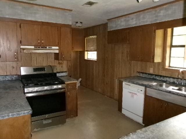 kitchen featuring brown cabinets, under cabinet range hood, stainless steel gas stove, visible vents, and white dishwasher