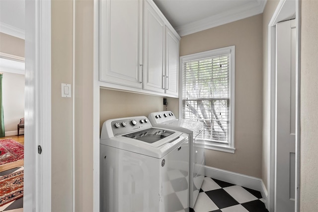 laundry room with tile patterned floors, washing machine and dryer, crown molding, baseboards, and cabinet space