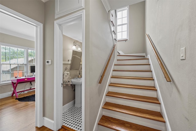 stairway with wood finished floors and baseboards