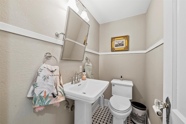 half bath featuring toilet and a sink
