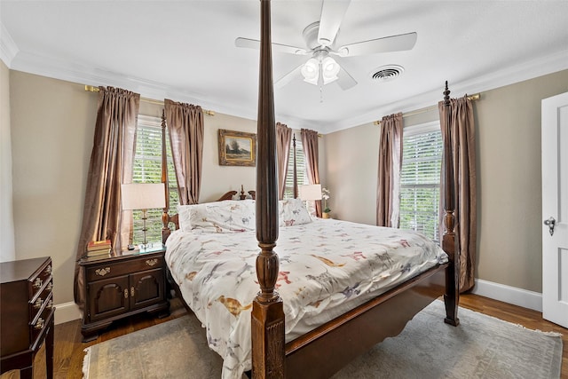 bedroom with visible vents, crown molding, baseboards, and multiple windows