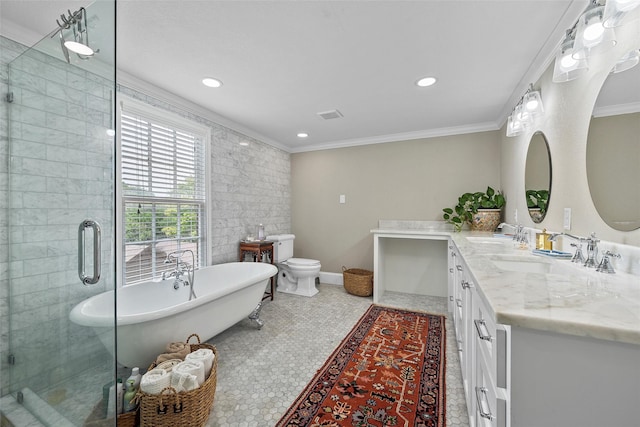 bathroom featuring a freestanding bath, crown molding, a sink, and visible vents