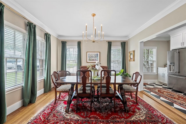 dining space with plenty of natural light, baseboards, a chandelier, and crown molding